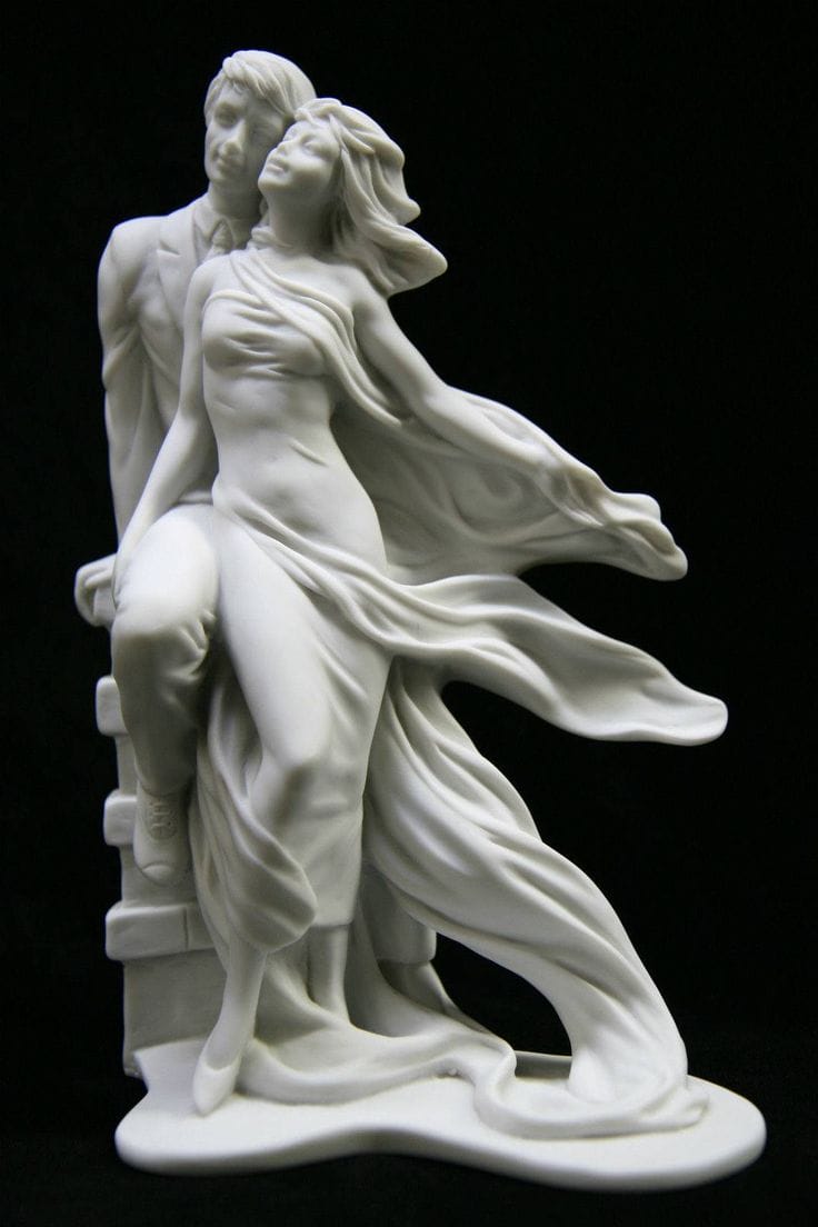 Une statue de marbre blanc représente un homme en costume et une femme à la robe flottante, tous deux regardant vers le haut, leurs expressions évoquant la complexité des relations et les différents types de sexualité.