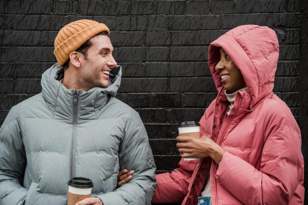 Deux personnes souriantes profitant d'un rendez-vous sobre avec leur boisson chaude sans alcool.  